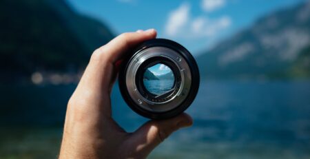 person holding camera lens