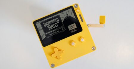 a yellow and black gameboy with a white background